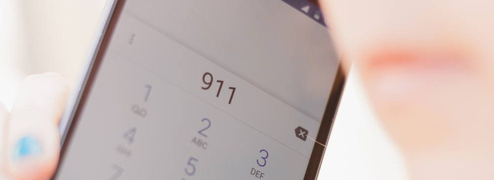 Close-up shot of a woman calling 911 on her smartphone