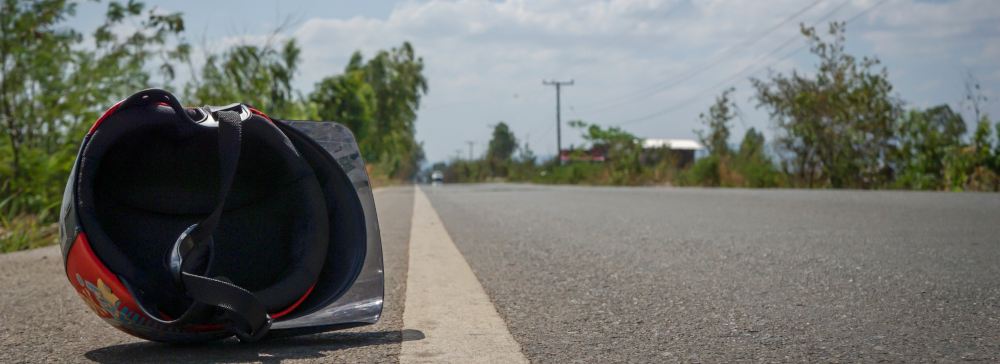 A motorcycle helmet laying on the side of the road