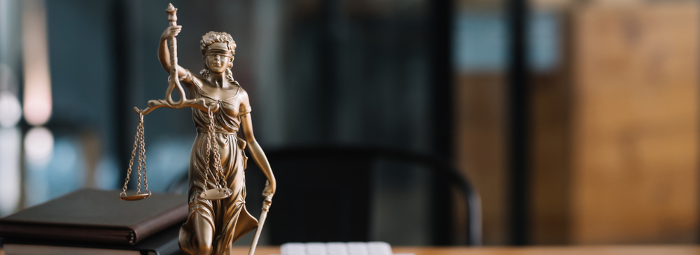 A small statue of lady justice on a desk