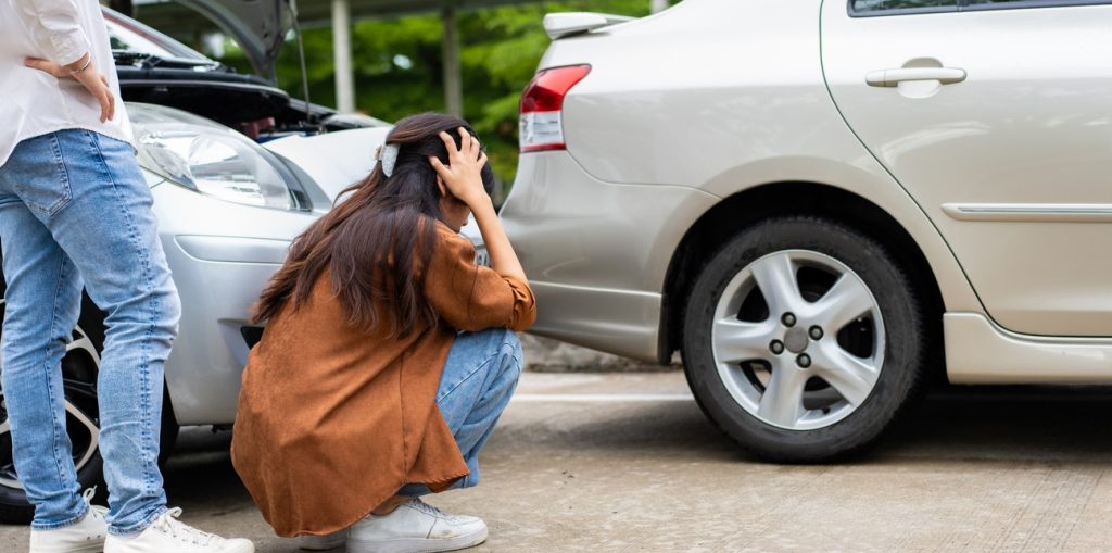 Woman checking damages after a car accident