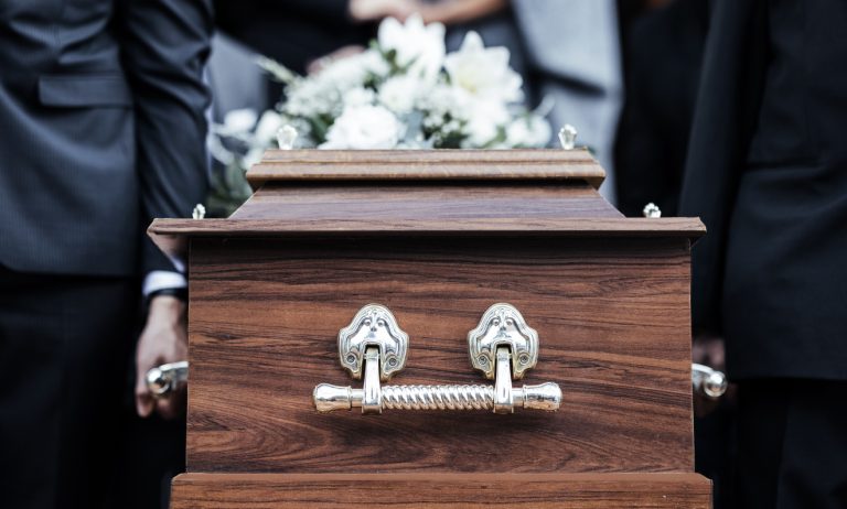 Coffin, people and funeral with death, grief and service with family carry casket to grave outdoor. Rip, farewell and ceremony or event for dead person together in respect, religion and spiritual